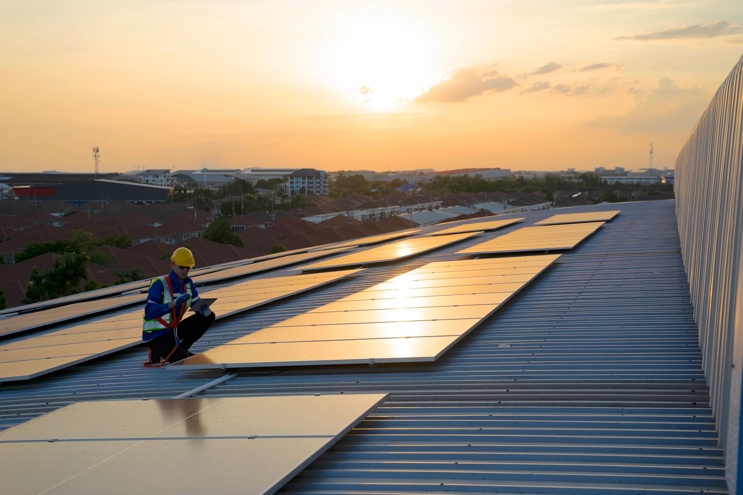 Worker servicing rooftop solar panels